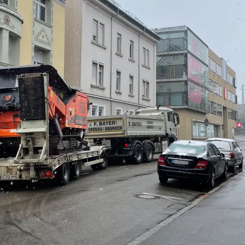 Transport: LKW mit Baumaschine im Winter. Erdbau, Abbruch.